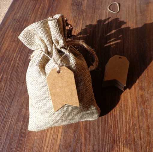 Petite étiquette kraft en forme de flèche accrochée à un sac de lin