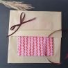 Emballage réalisé avec du papier de soie couleur kraft et ruban bordeaux.