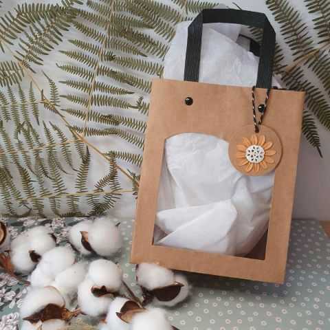 Petit sac cadeau garni de papier de soie blanc.