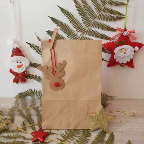Étiquette forme rennes accrochée à un paquet de Noël avec un lien rouge