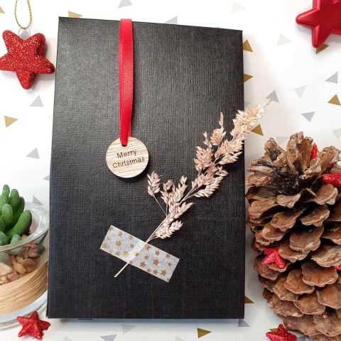 Etiquette en bois Merry Christmas sur un paquet noir