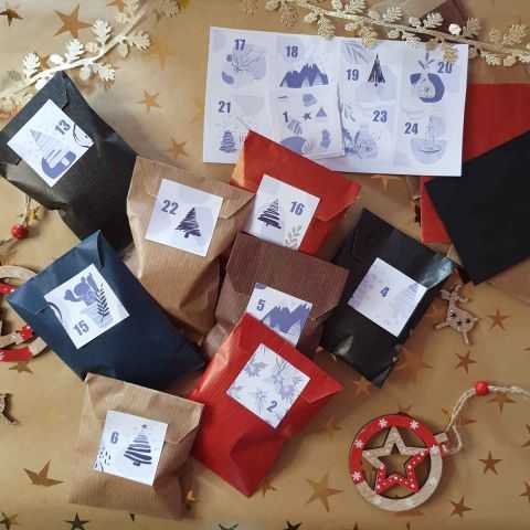 Stickers pour calendrier de l'avent positionnés sur sachets kraft cadeaux