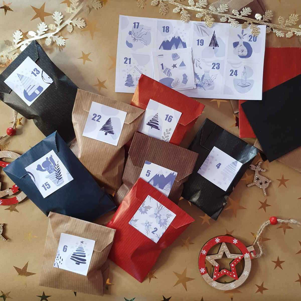 Stickers pour calendrier de l'avent positionnés sur sachets kraft cadeaux