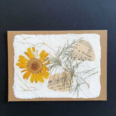 Carte en papier artisanal avec fleur jaune et notes de musique
