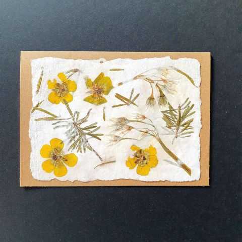 Carte artisanale avec inclusions florales couleur jaune et blanc