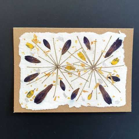 Carte artisanale unique avec inclusions végétales.