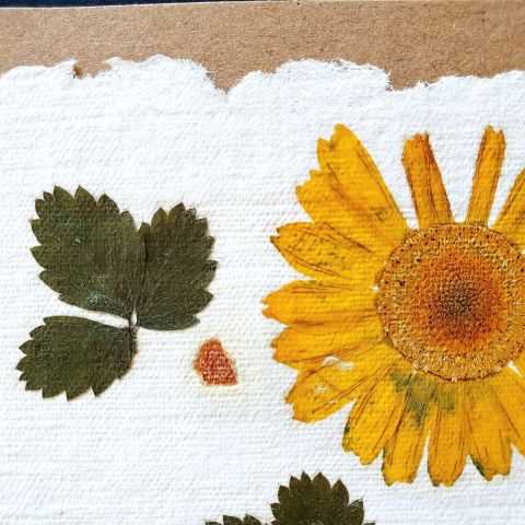 détail du papier artisanal avec feuilles de fraisier en inclusion