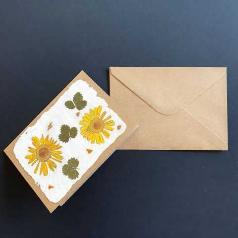 Carte kraft en papier artisanal avec des fleurs jaunes et feuilles de fraisier