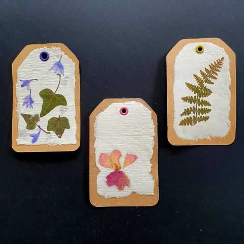 3 Etiquettes en papier artisanal avec inclusions florales.