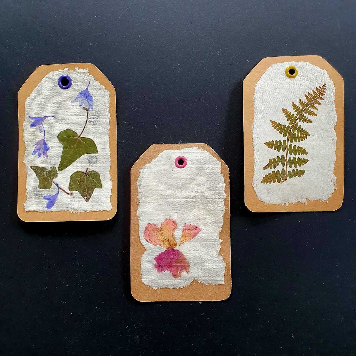 3 Etiquettes en papier artisanal avec inclusions florales.