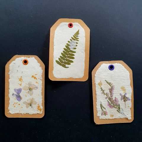 Trios d'étiquettes artisanales avec fleurs séchées.