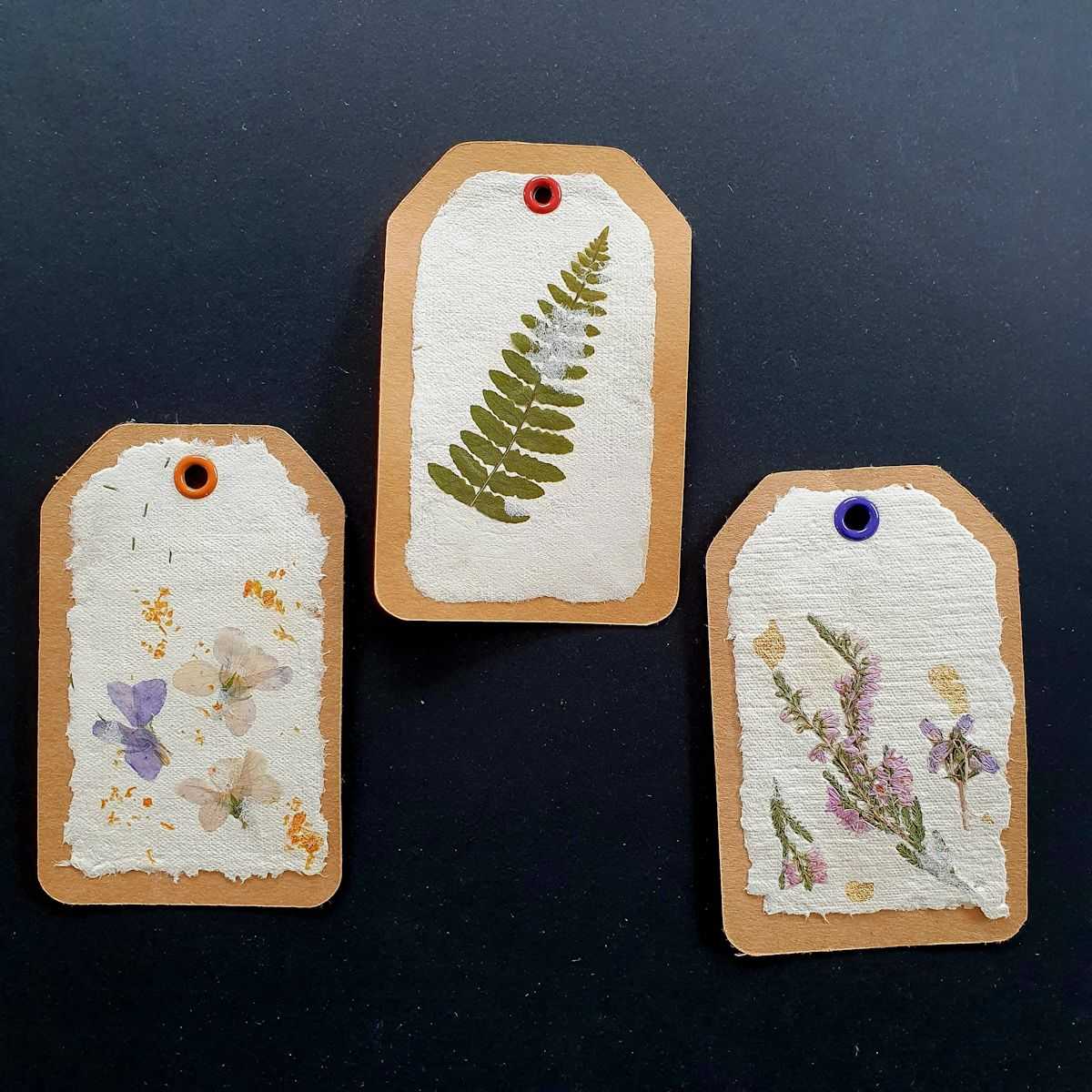 Trios d'étiquettes artisanales avec fleurs séchées.