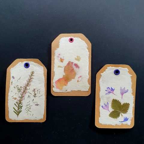 Etiquettes kraft sur papier artisanal avec fleurs séchées
