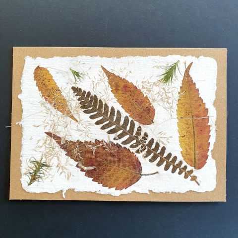 Carte avec papier artisanal et inclusion de feuilles.
