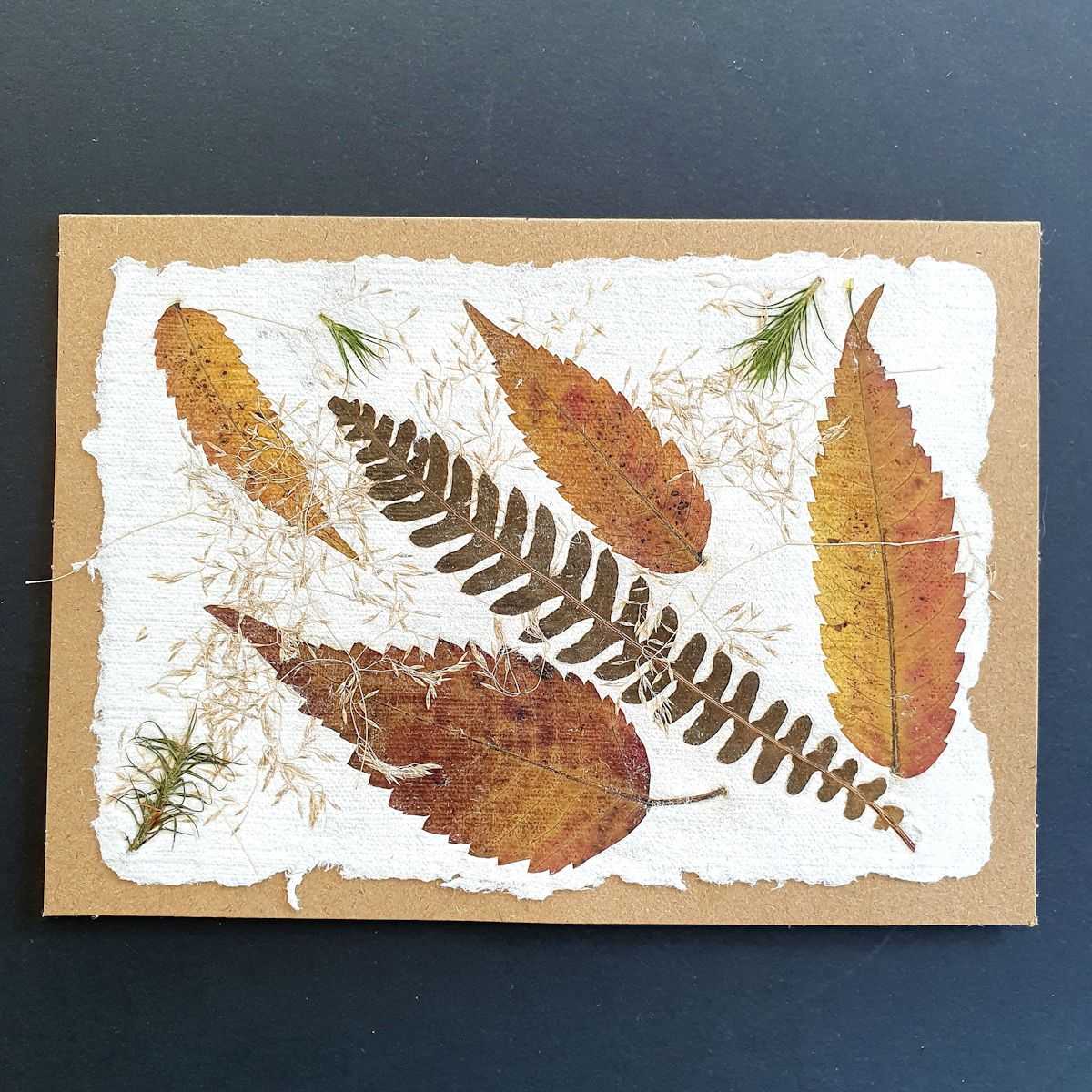 Carte avec papier artisanal et inclusion de feuilles.